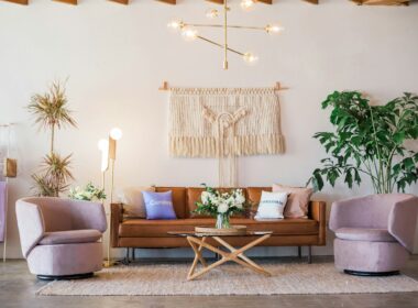 brown leather sofa and two pink sofa chair